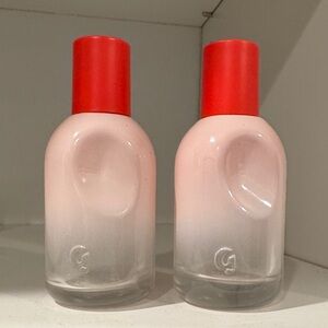 2 empty Glossier perfume bottles